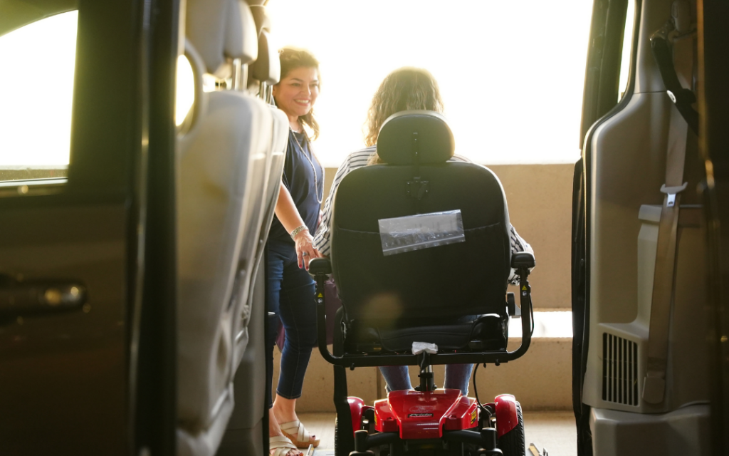 Young lady in electric wheelchair exiting a specialized van