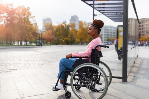 woman in wheelchair alone at a bus stop
