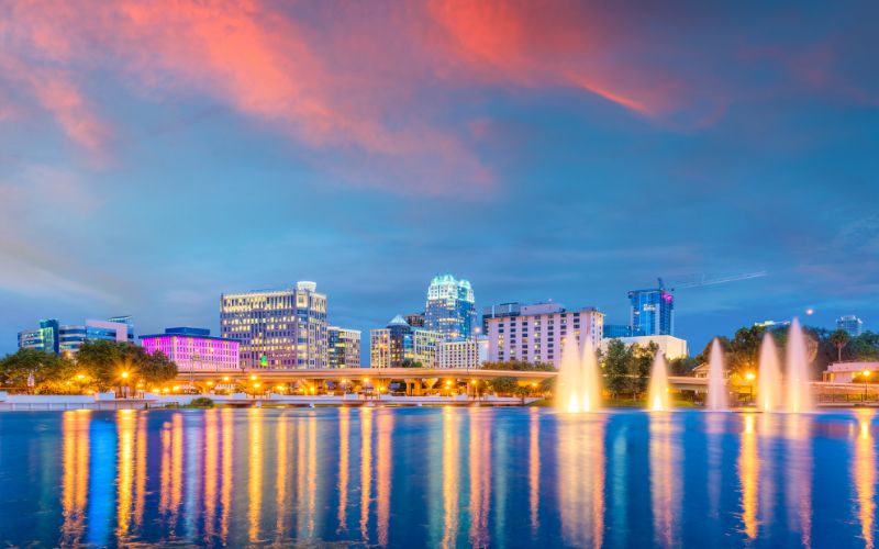 Orlando Cityscape Taken from the Water and Featuring Brightly Lit Buildings at Dusk